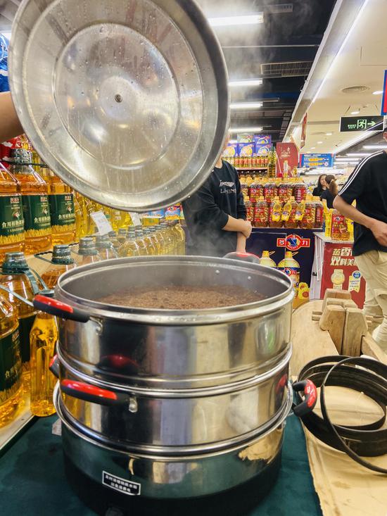 一旁的蒸笼正往外冒烟,里面蒸的正式即将用来榨油的茶坯.